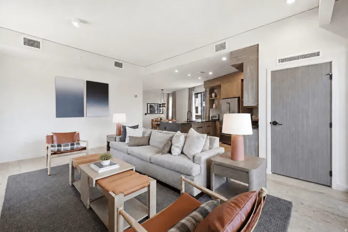 Open-concept layout with wood-finish flooring, recessed lighting, and a modern kitchen featuring wood cabinetry and a stainless steel refrigerator