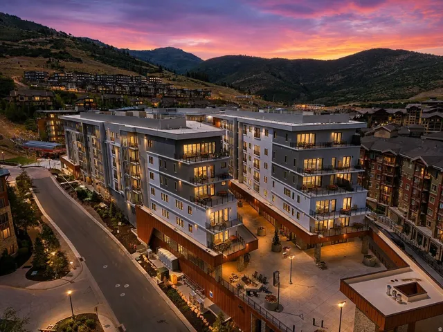 Modern multi-story buildings featuring balconies with glass railings