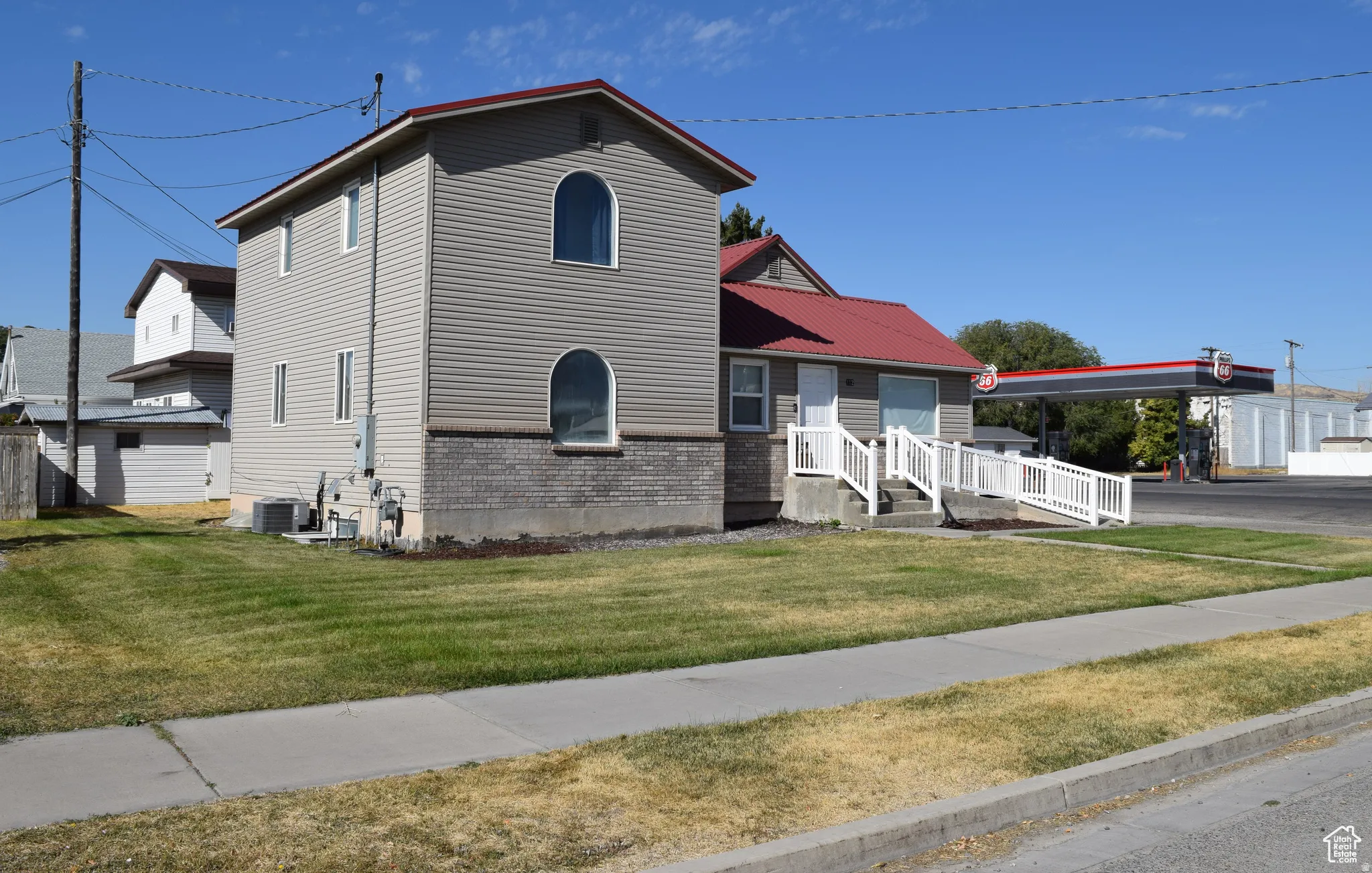 Two-story exterior with horizontal siding and a red metal roof