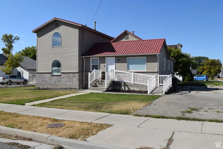 Two-story exterior with horizontal siding and a red metal roof