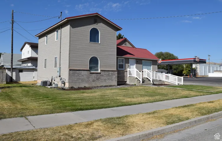 Two-story exterior with horizontal siding and a red metal roof