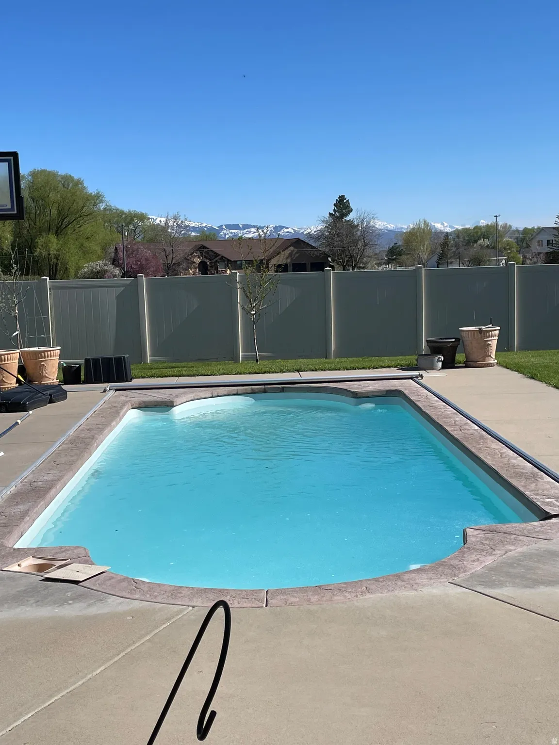 In-ground pool featuring a concrete surround and a light blue interior finish