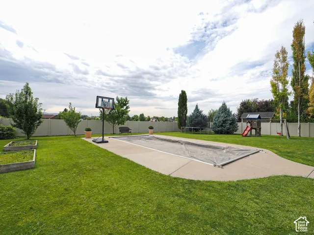 Expansive green lawn with a covered in-ground pool, concrete surround, and perimeter fencing