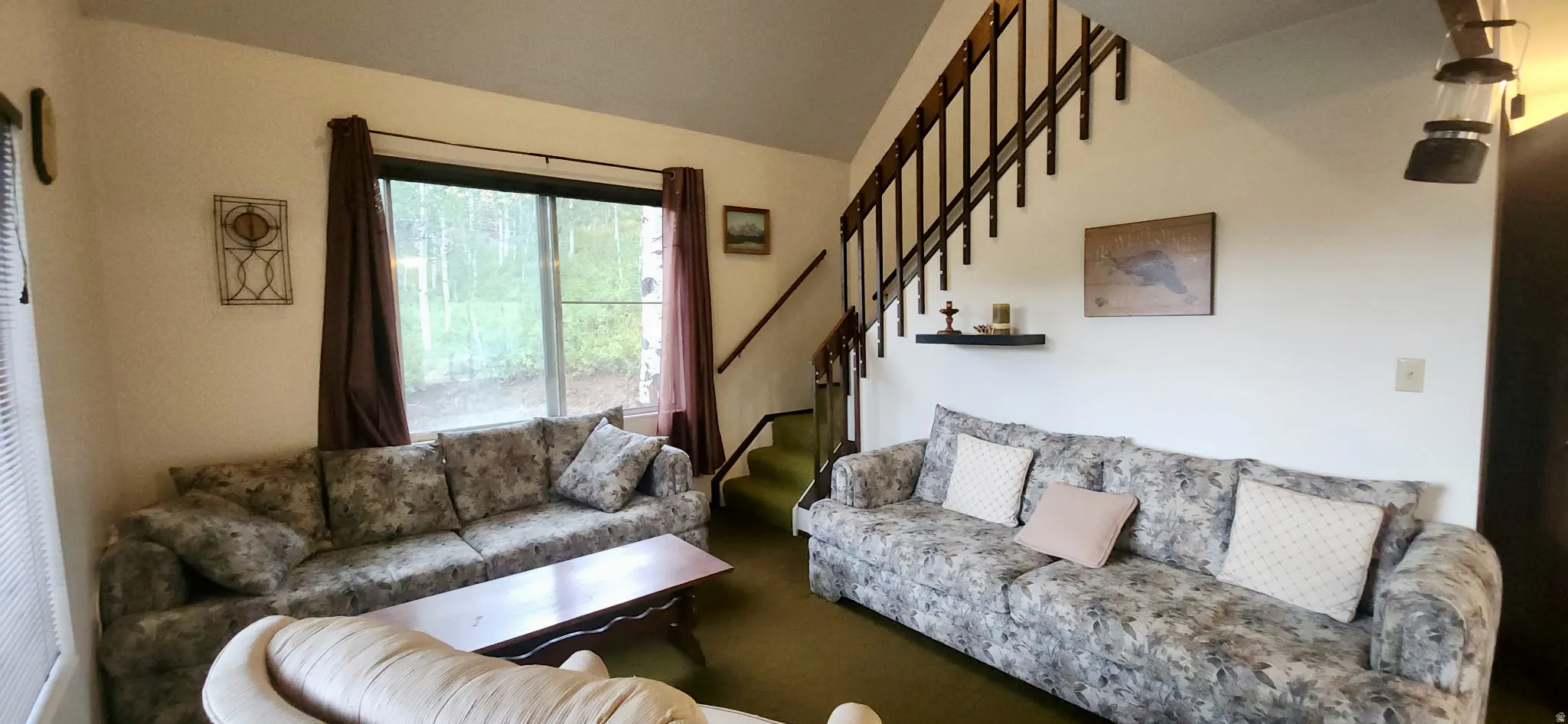 Vaulted ceiling with an open staircase featuring wood railings