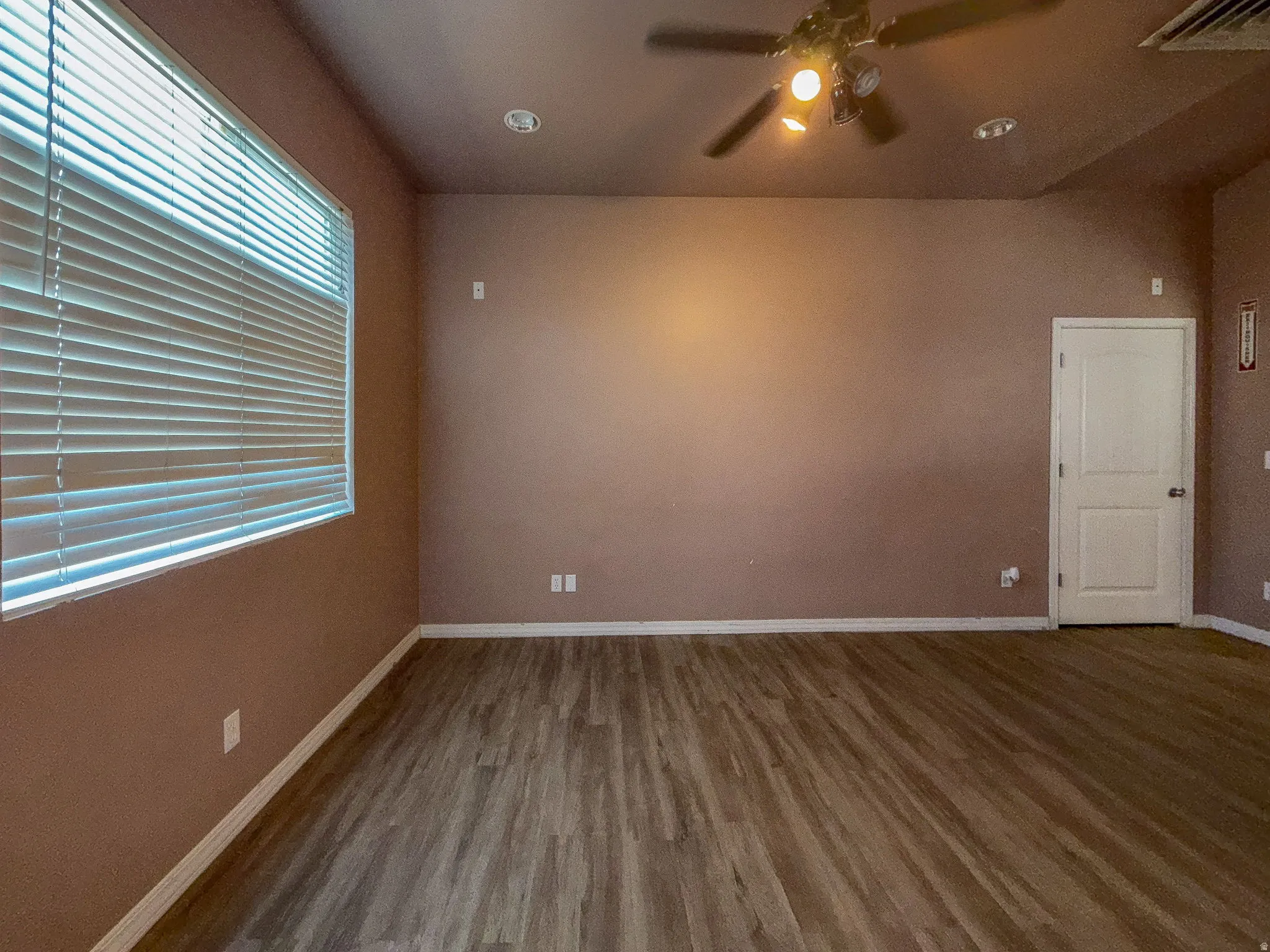 Wood-finish flooring, recessed lighting, and a ceiling fan with integrated lighting
