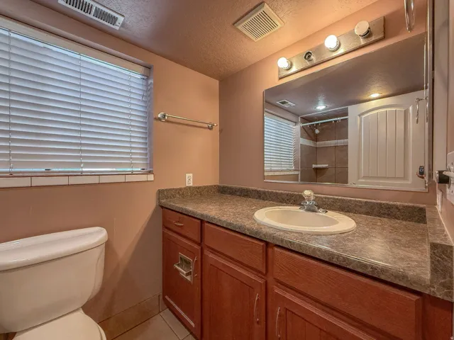 Vanity with an integrated sink, laminate countertop, and wood-finish cabinetry