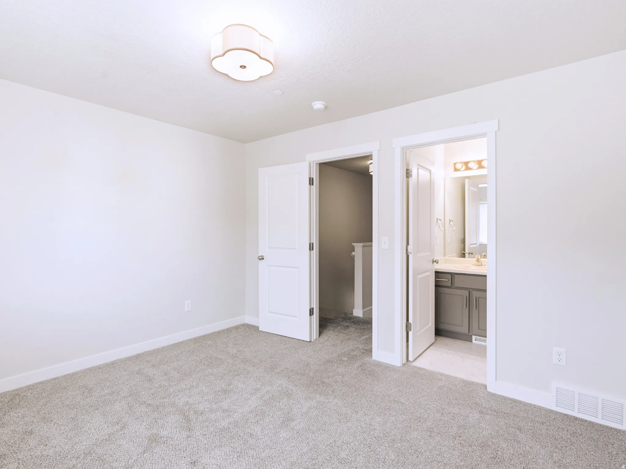 Plush carpeting, bright white walls, and a decorative ceiling light fixture