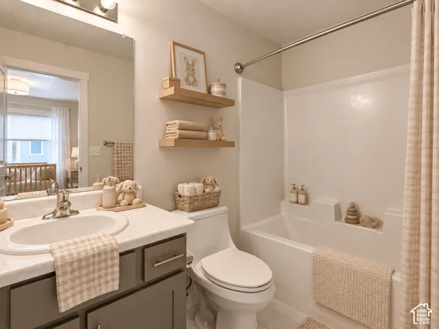 Bathroom featuring a vanity with a white countertop and oval under-mount sink, two wall-mounted wood-finish floating shelves, a large wall-mounted mirror, and a tub-shower combination with integrated shelving