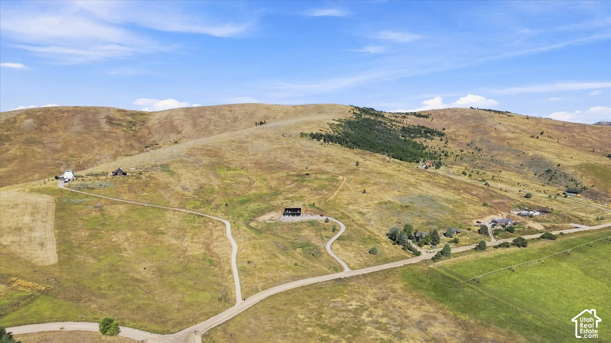 Expansive rural terrain with multiple structures and winding access roads