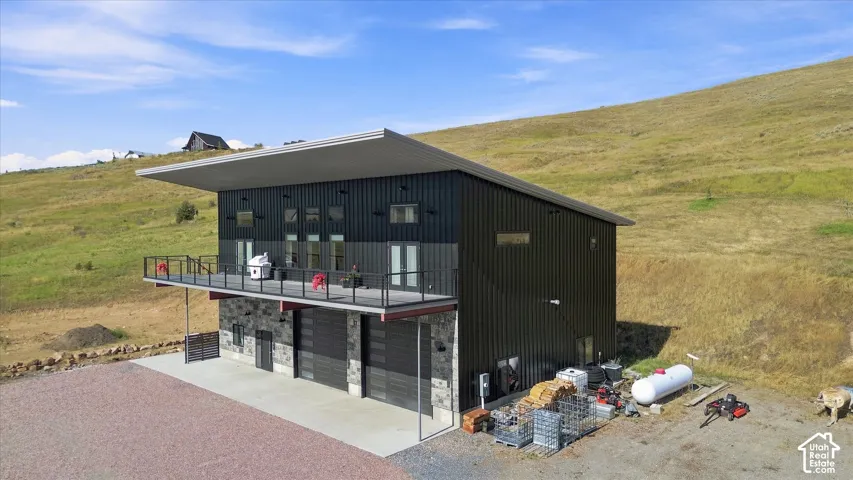 Modern exterior with dark vertical siding and a stone-clad lower level