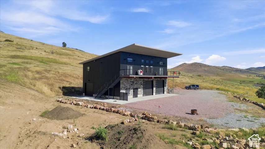 Modern exterior with a flat roof, dark panel siding, and a stone facade