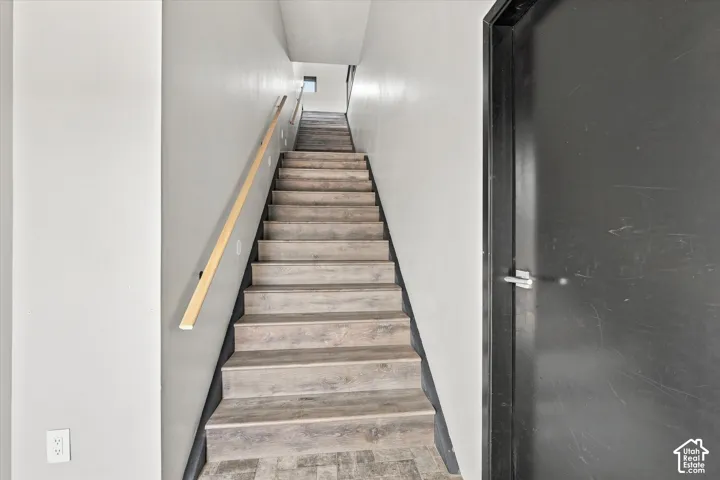 Staircase with wood-finish treads and risers, complemented by a light wood handrail