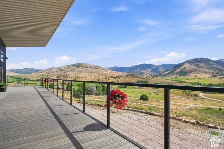 Expansive outdoor deck with gray composite flooring, black metal railing, and glass balusters
