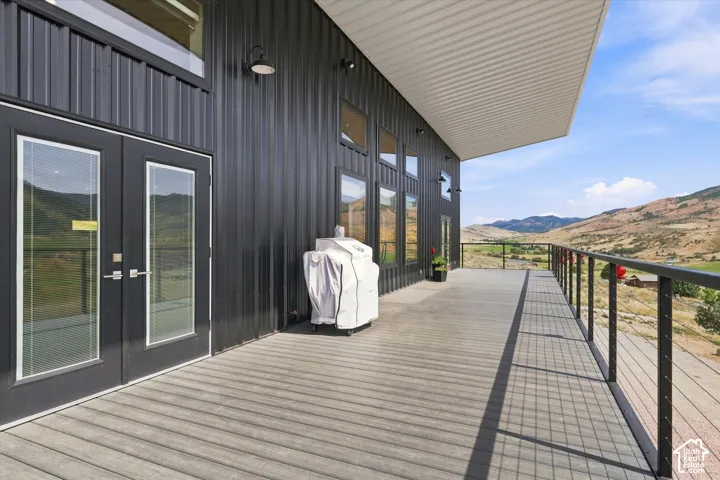Expansive outdoor deck featuring wood-finish flooring and black metal railings