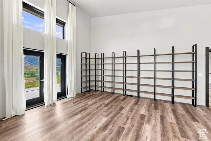 High ceilings with integrated shelving, wood-finish flooring, and multiple exterior doors