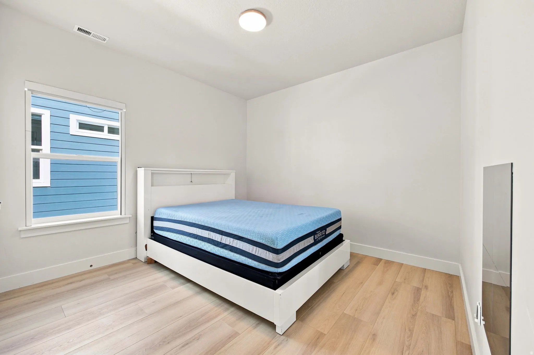 Bright interior with wood-finish flooring and a single window