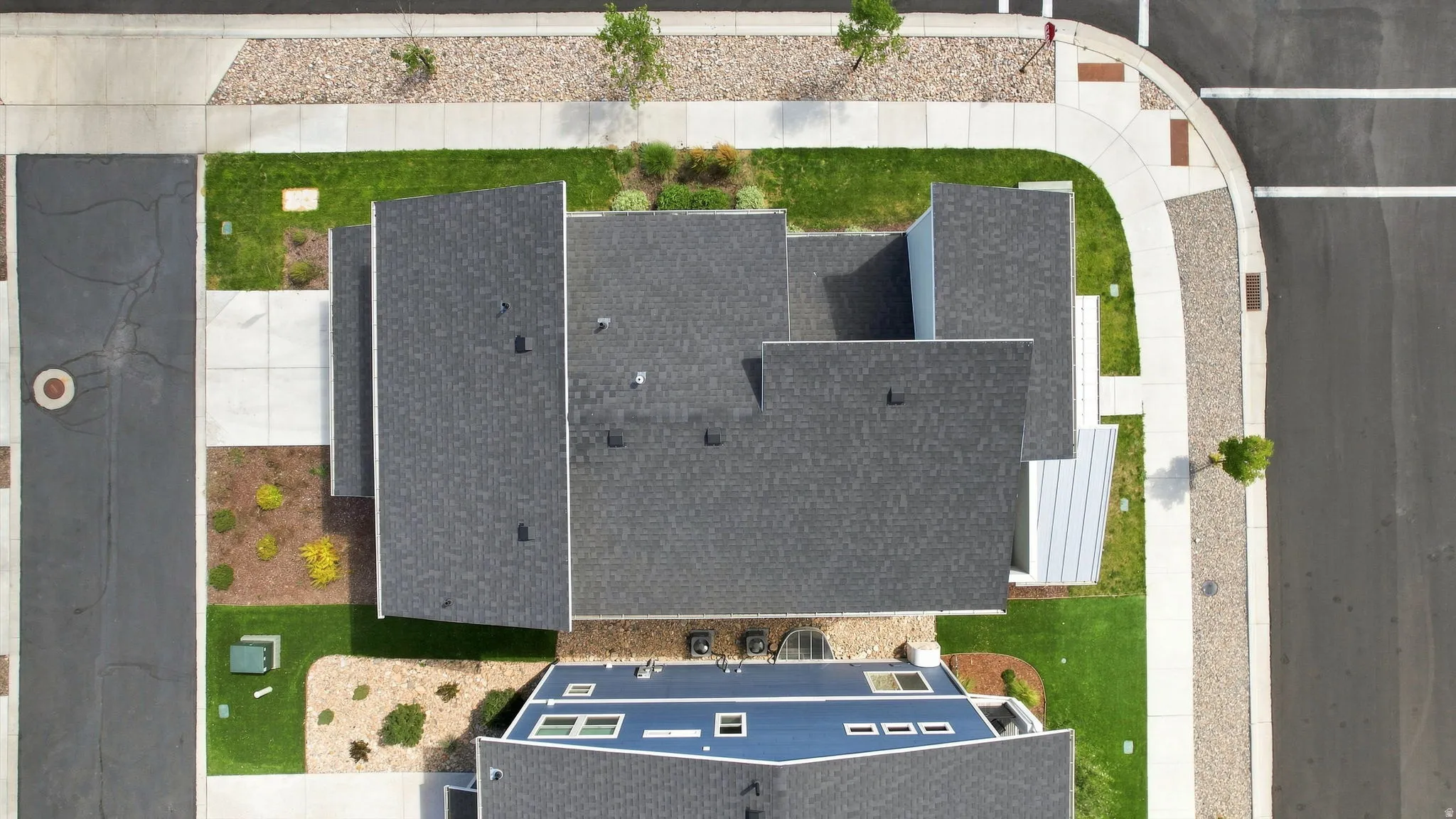 Contemporary pitched roofs, landscaped grounds, concrete sidewalks, and paved roadways