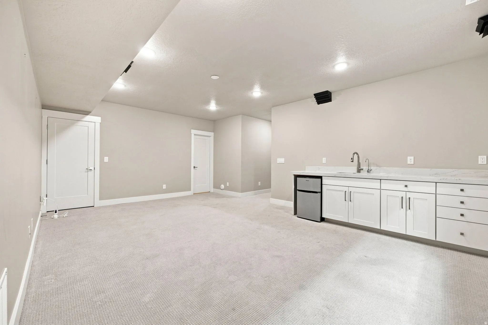 Open concept room with white baseboard trim and recessed lighting