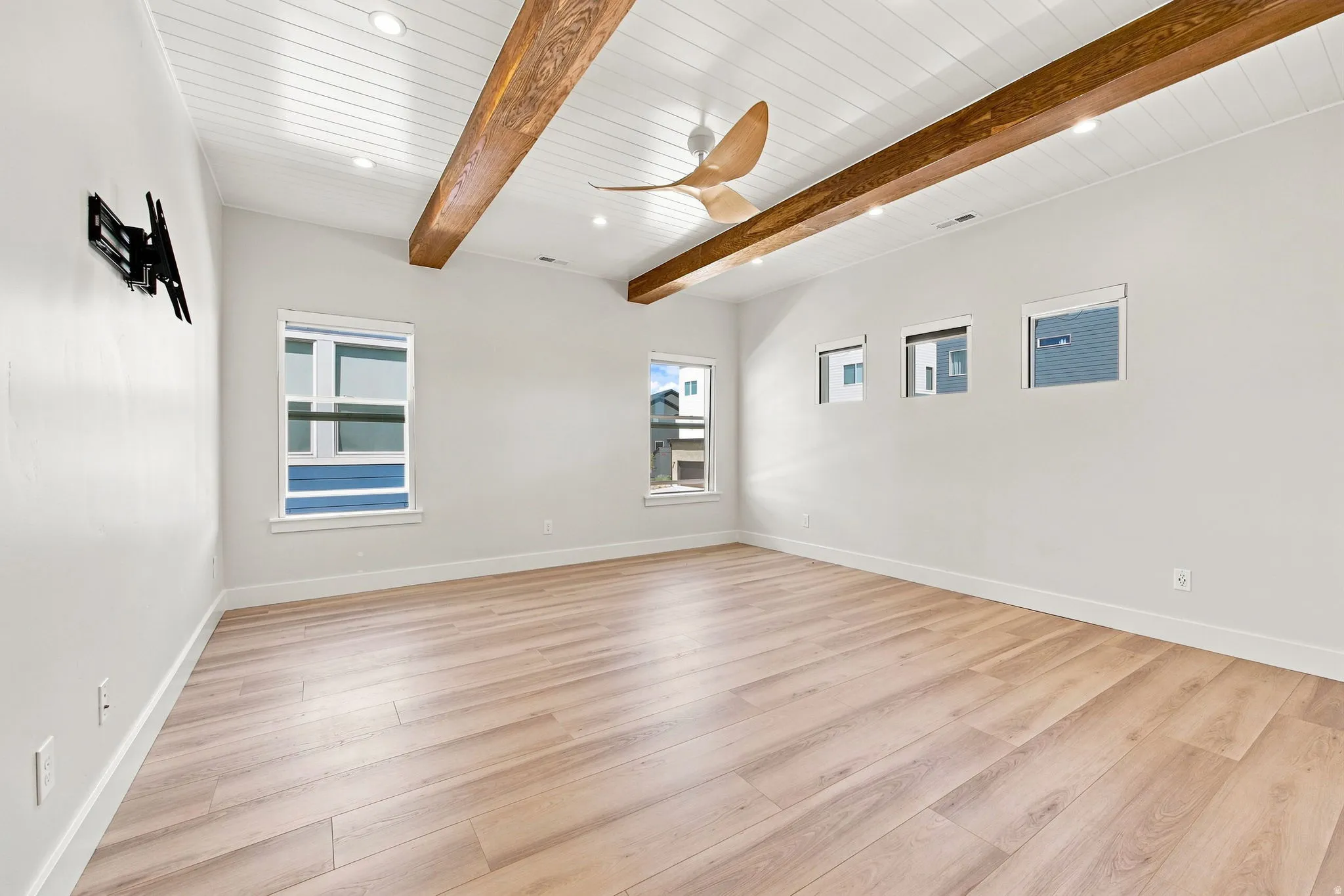 Vaulted shiplap ceiling with exposed wood beams, recessed lighting, wood-finish flooring, and multiple window placements