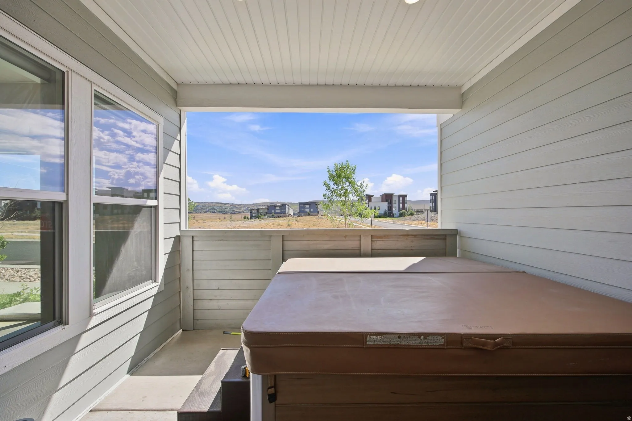 Covered patio with siding exterior, recessed lighting, and a built-in hot tub