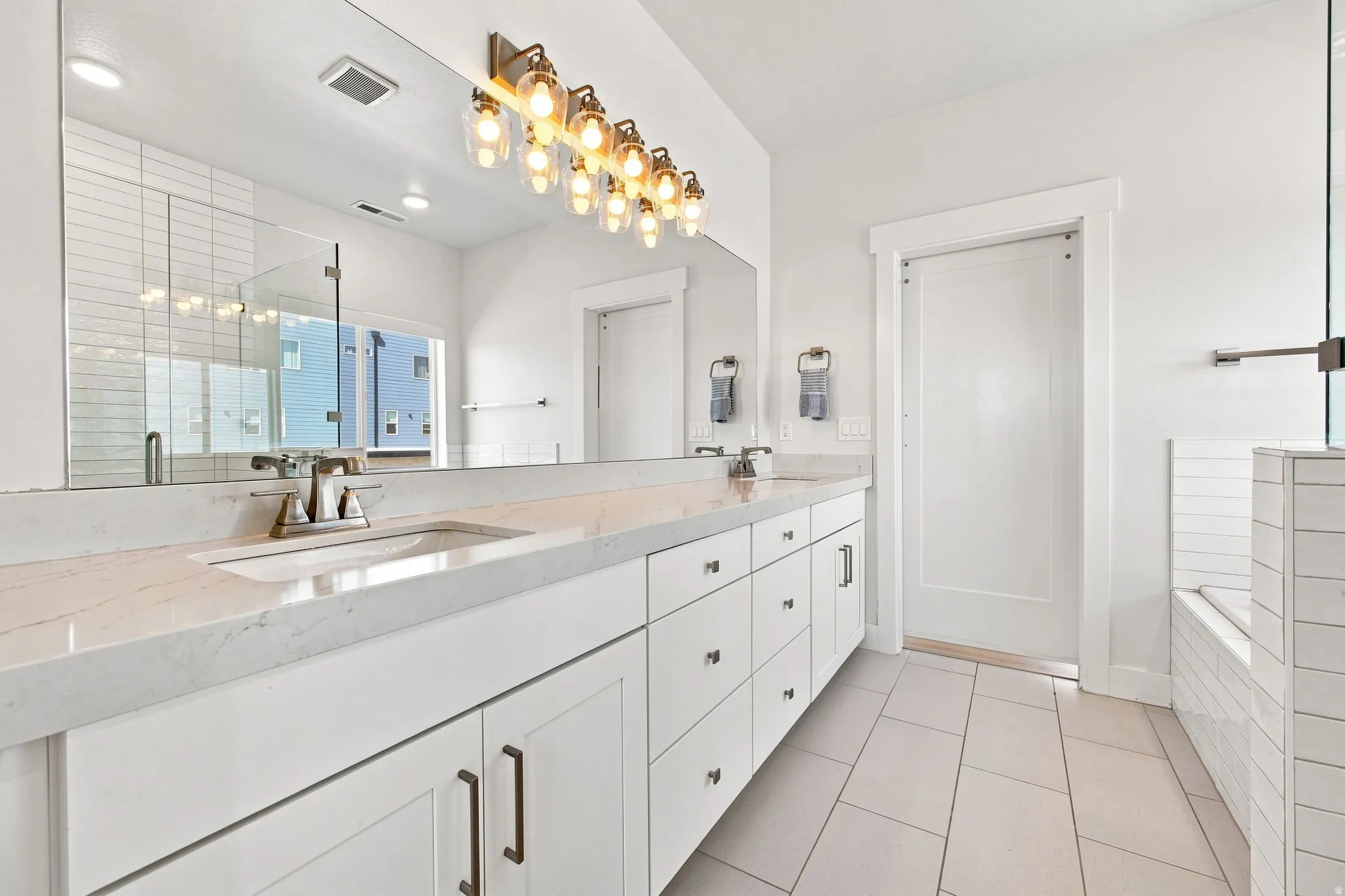 Dual sink vanity with quartz-finish countertop and white cabinetry