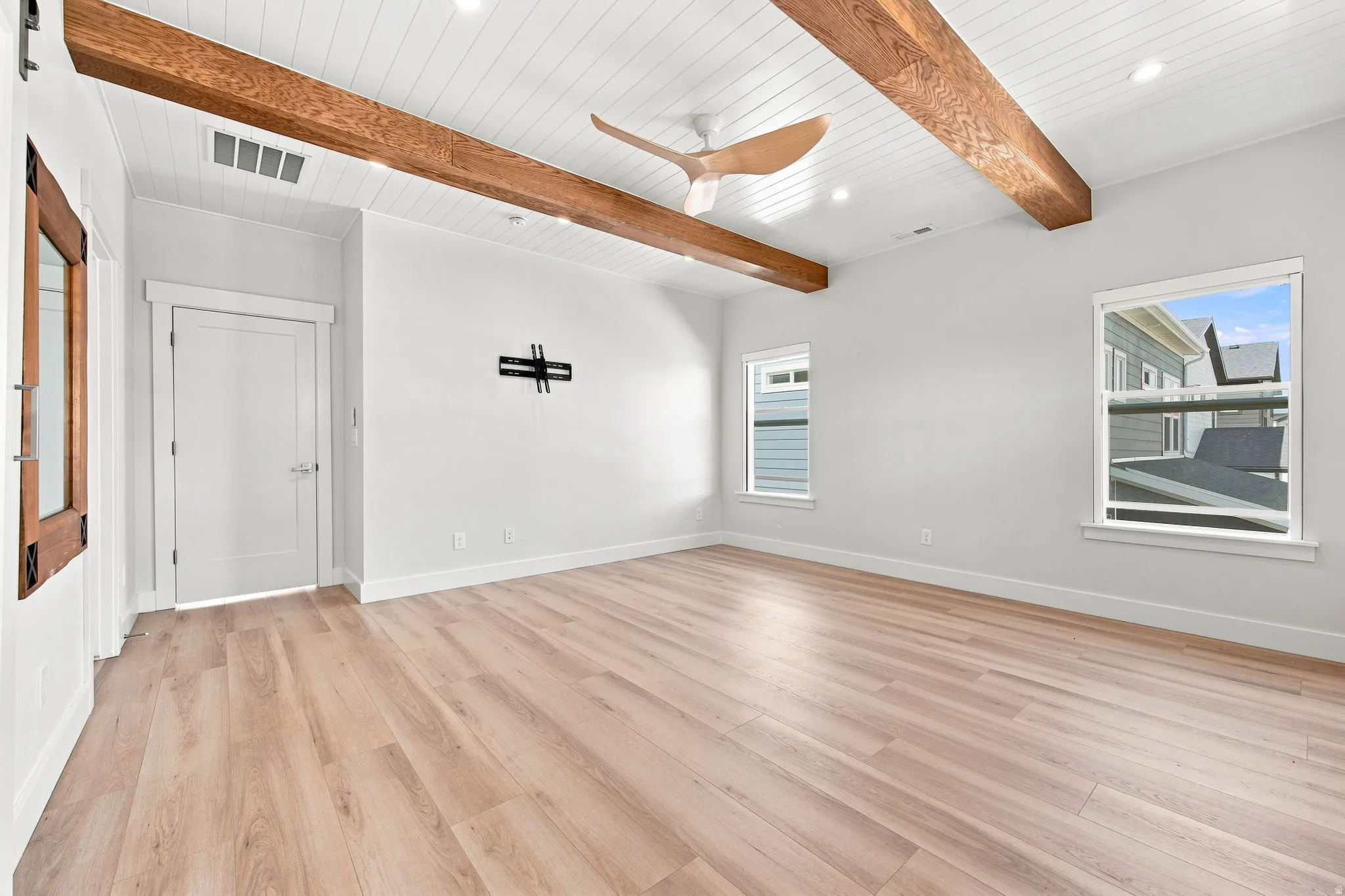 Vaulted ceiling with wood-finish beams, recessed lighting, and a ceiling fan