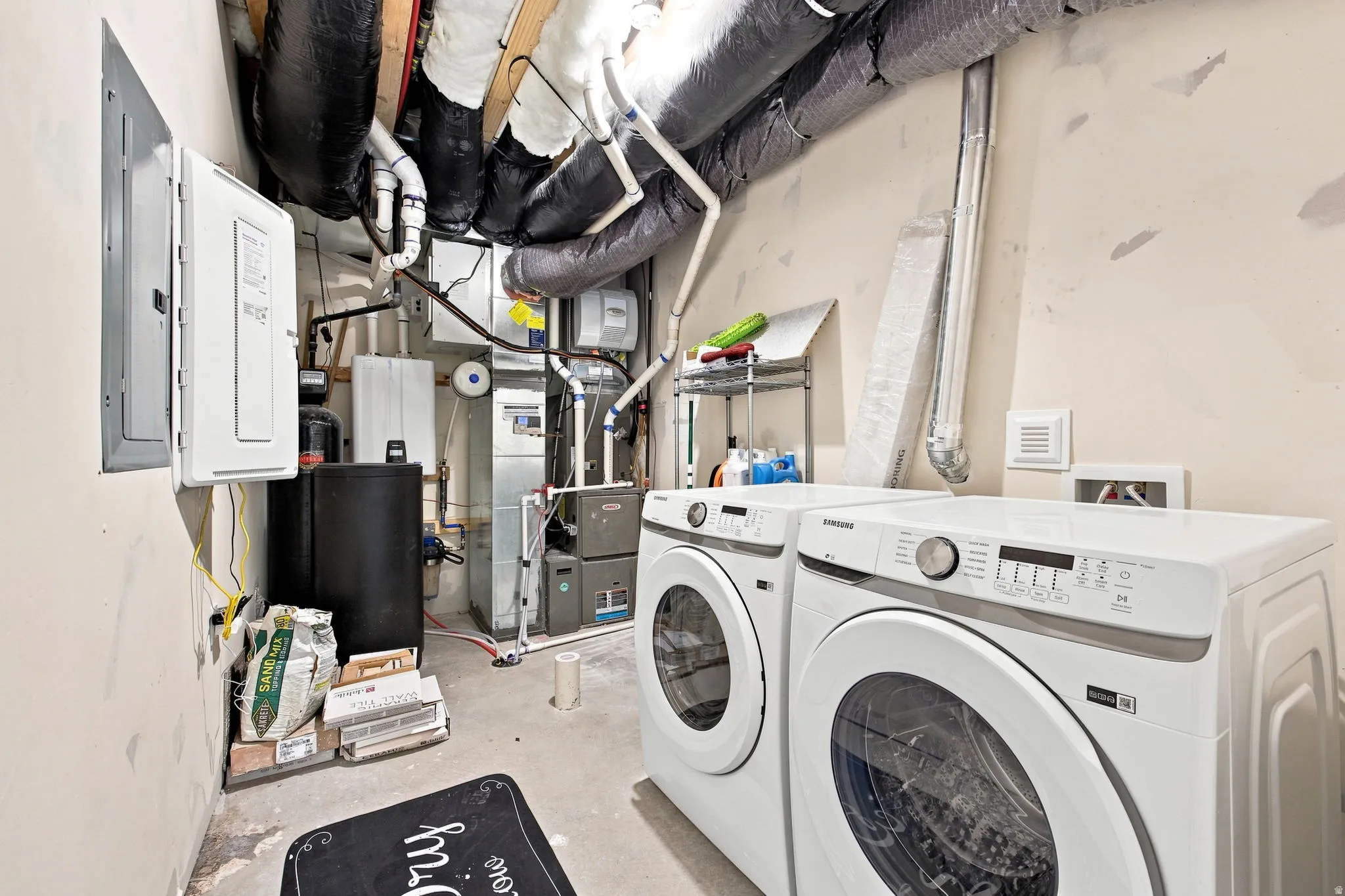 Utility room with exposed ductwork, concrete flooring, and an electrical service panel
