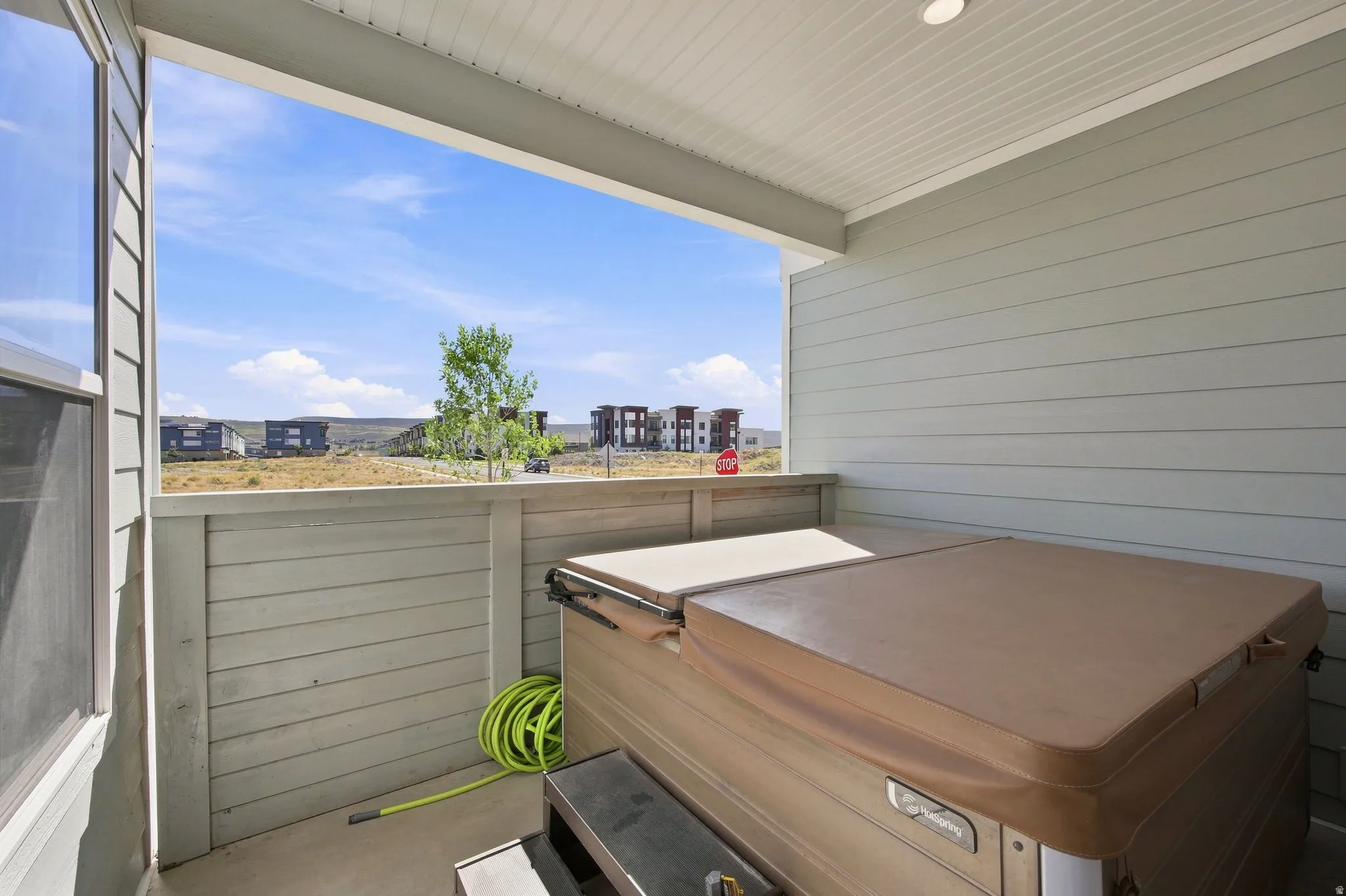 Covered patio featuring a hot tub, horizontal siding, and concrete flooring