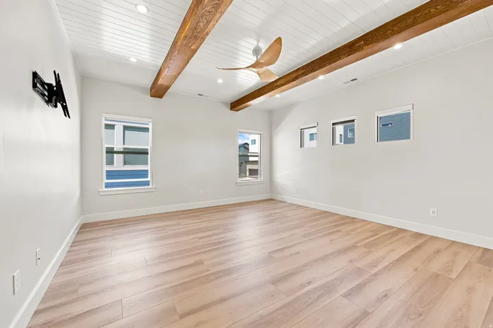 Vaulted shiplap ceiling with exposed wood beams, recessed lighting, wood-finish flooring, and multiple window placements