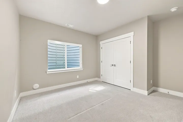 Neutral tone wall paint, white trim, light-colored carpet flooring, recessed lighting, and double doors