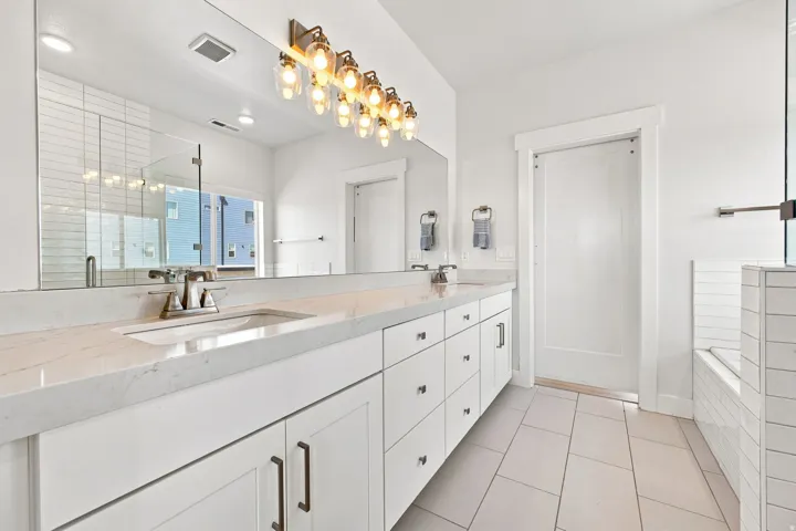 Dual sink vanity with quartz-finish countertop and white cabinetry