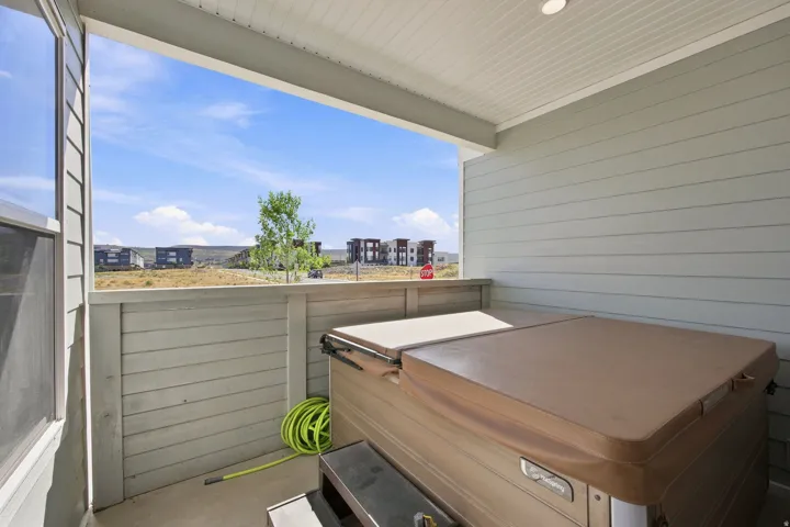 Covered patio featuring a hot tub, horizontal siding, and concrete flooring