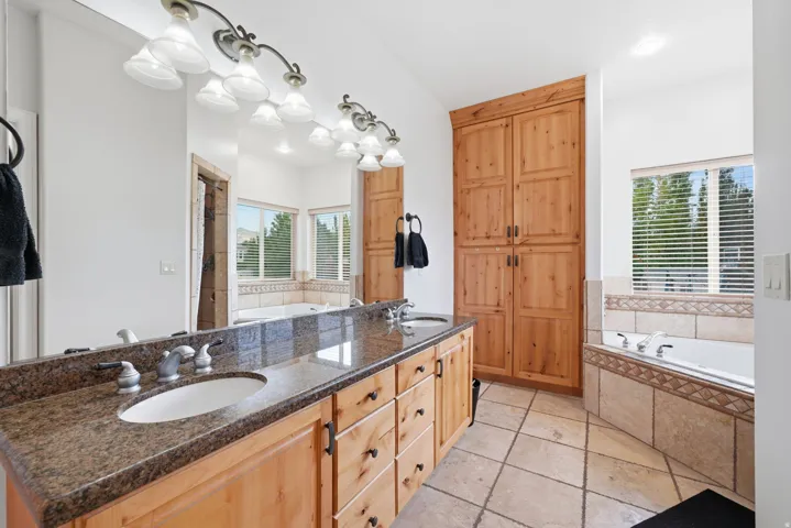Primary bathroom with Dual granite vanity, jetted tum and builtin cabinets.