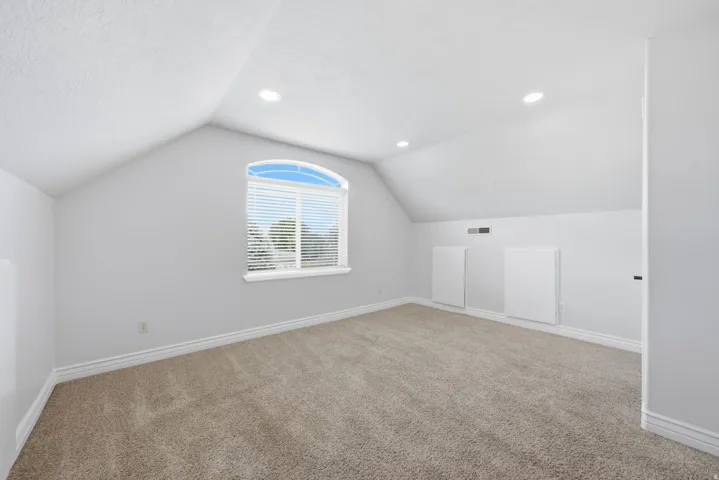 Large bedroom with walk-in closet with arched window with mountain views.