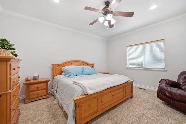 Primary bedroom, Crown molding, recessed lighting, and a ceiling fan