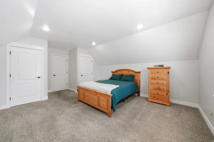 Sloped ceilings, recessed lighting, and carpeted flooring, with two walk-in closets