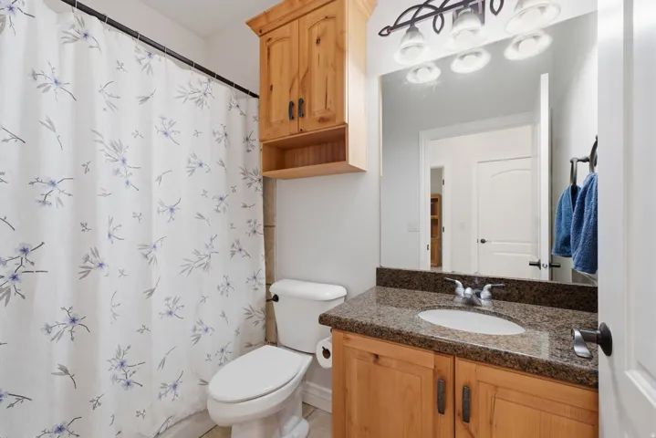 Wood-finish vanity with an integrated sink and a granite-finish countertop