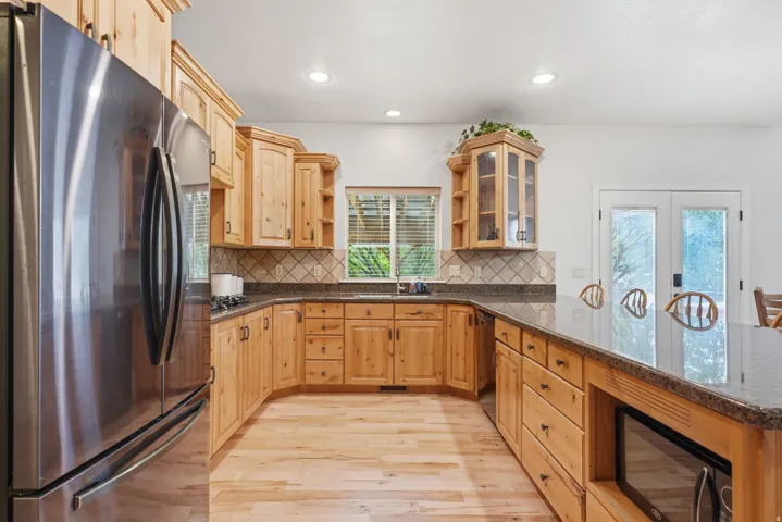 Large open kitchen with custom cabinets, granite countertops and gas stovetop.