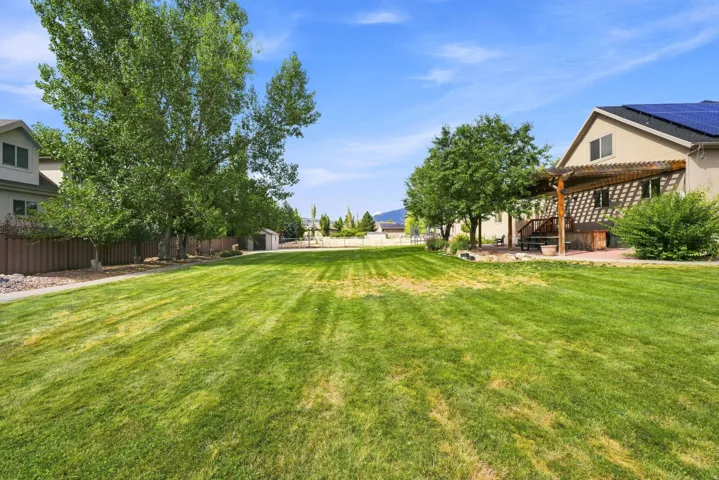 Expansive grassy lawn with mature trees and sidewalks paths.