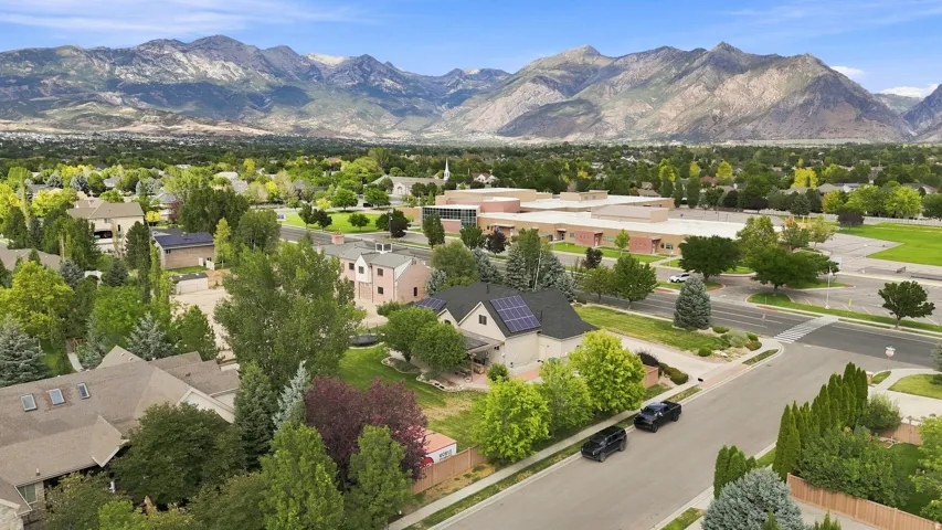 Expansive mountain backdrop with mature trees and established residences.