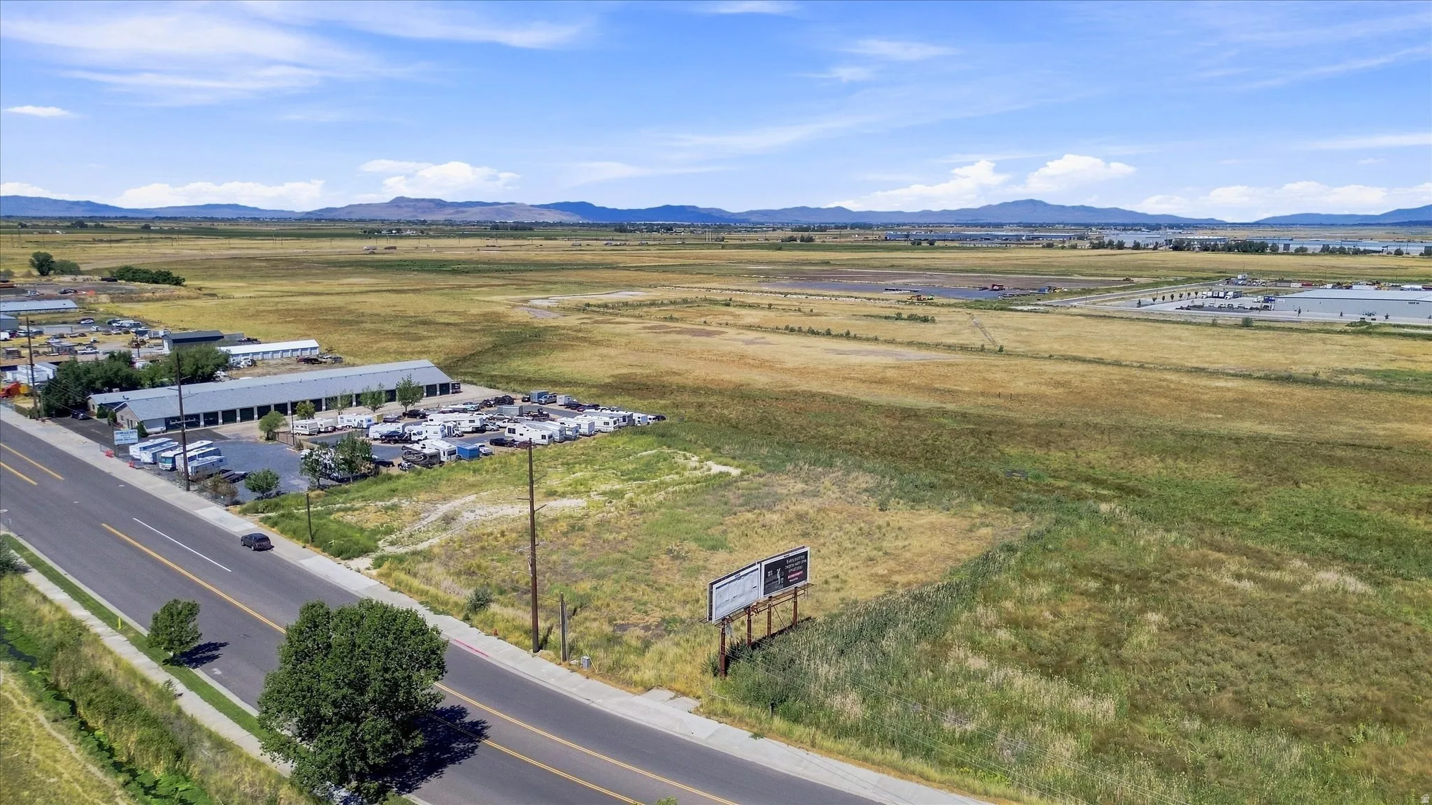 Road frontage with expansive land and distant mountain ranges