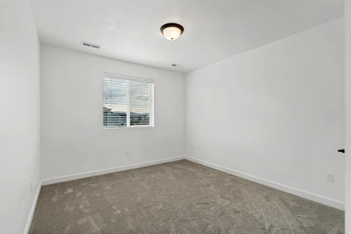 Window with horizontal blinds, flush mount ceiling light fixture, and carpeted flooring
