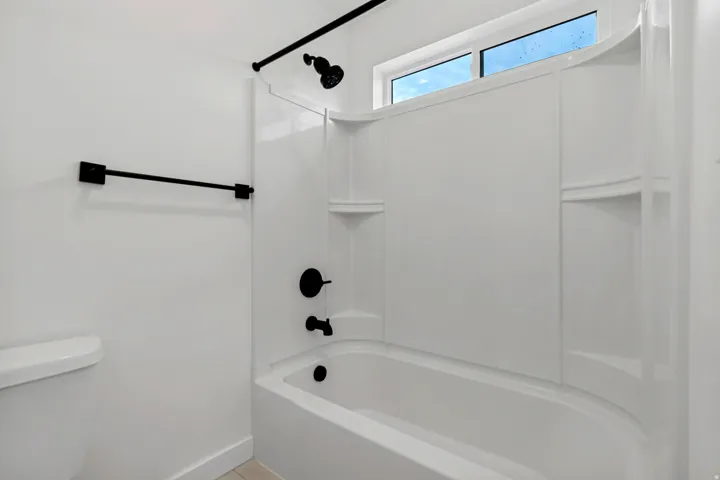 White shower/tub combination with integrated shelving
