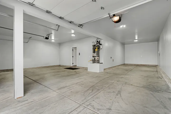 Spacious garage with concrete flooring, recessed lighting, and white painted walls