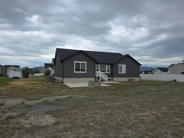 Dark gray exterior siding with white trim windows and a white deck staircase