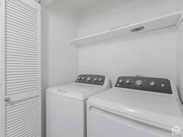Laundry area with white walls and an upper storage shelf