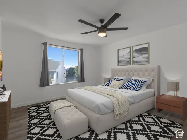 Bright bedroom featuring wood-finish flooring, a large window, a ceiling fan with integrated lighting, and white walls