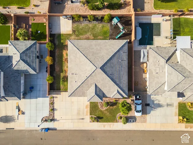 Gable roofline with gray shingles, concrete driveway, and front landscaping