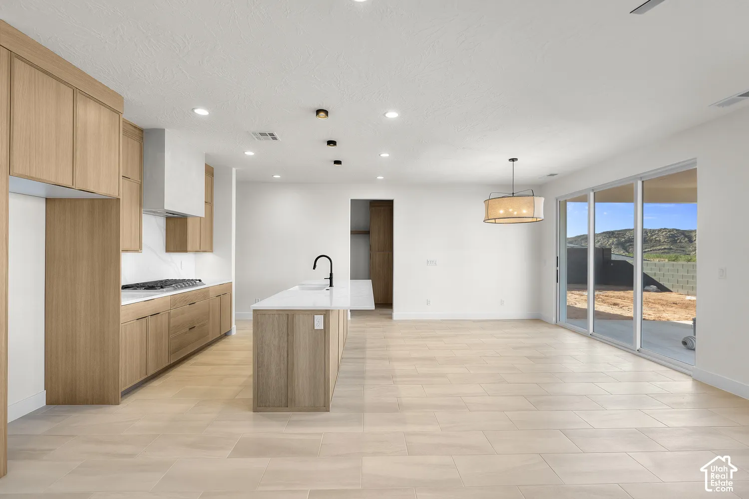 Modern kitchen with wood-finish cabinetry, white countertops, and stainless steel hood