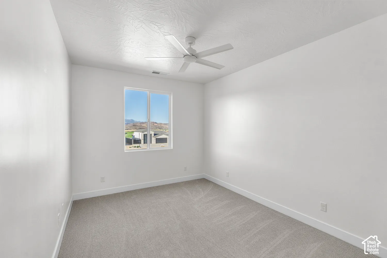 Recessed window with clear insulated glass, a white ceiling fan, and light neutral-toned carpeting